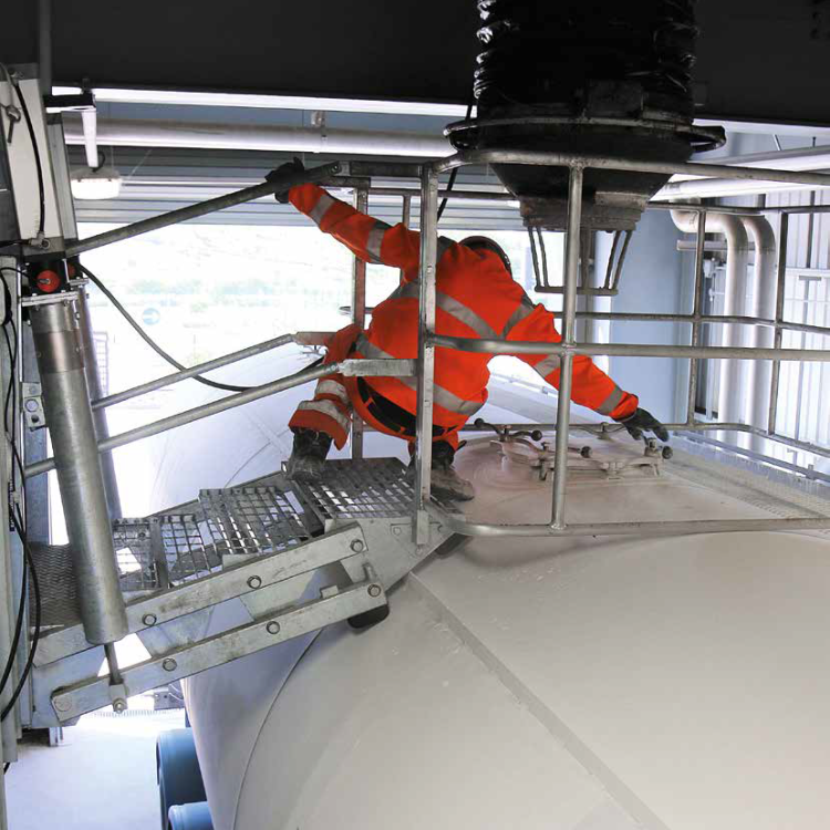 An operator using a EWFM Folding Stair Unit with Saftey Cage to access the top of his tanker
