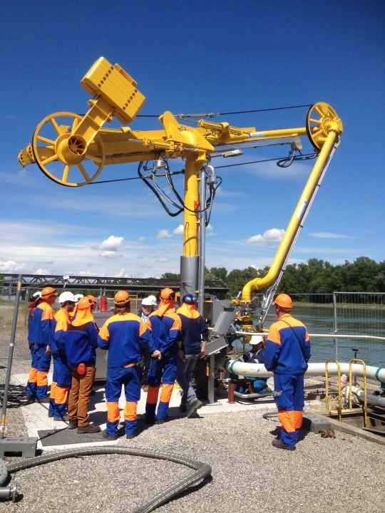 A group of engineers gathered round a newly installed Minerva Marine Loading Arm